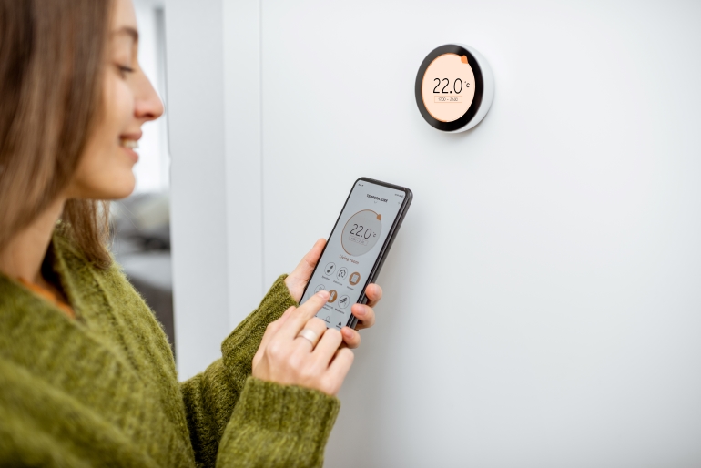 Woman using smart thermostat